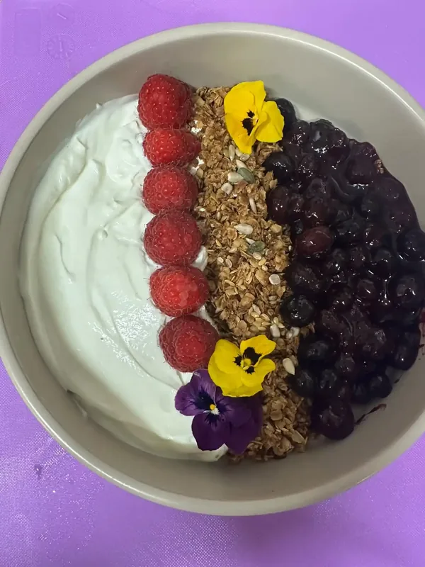 Crunchy breakfast bowl with Greek yoghurt, honey granola, chia seeds and vibrant fresh berry compote